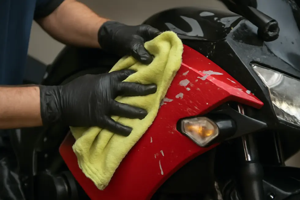 Utilizing controlled heat application to safely loosen sticker adhesive on a motorcycle fairing.