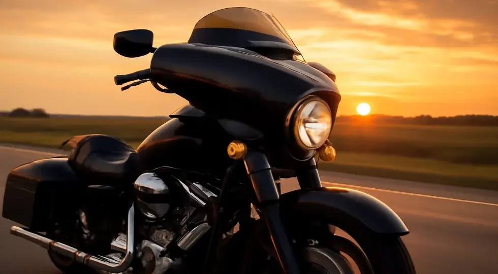 Sleek cruiser motorcycle equipped with an aerodynamic batwing fairing cruising at sunset.