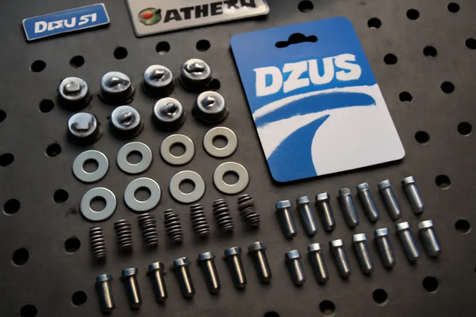 Close-up view of a DZUS fastener illustrating its quarter-turn pin design for quick release and installation on race bike fairings.