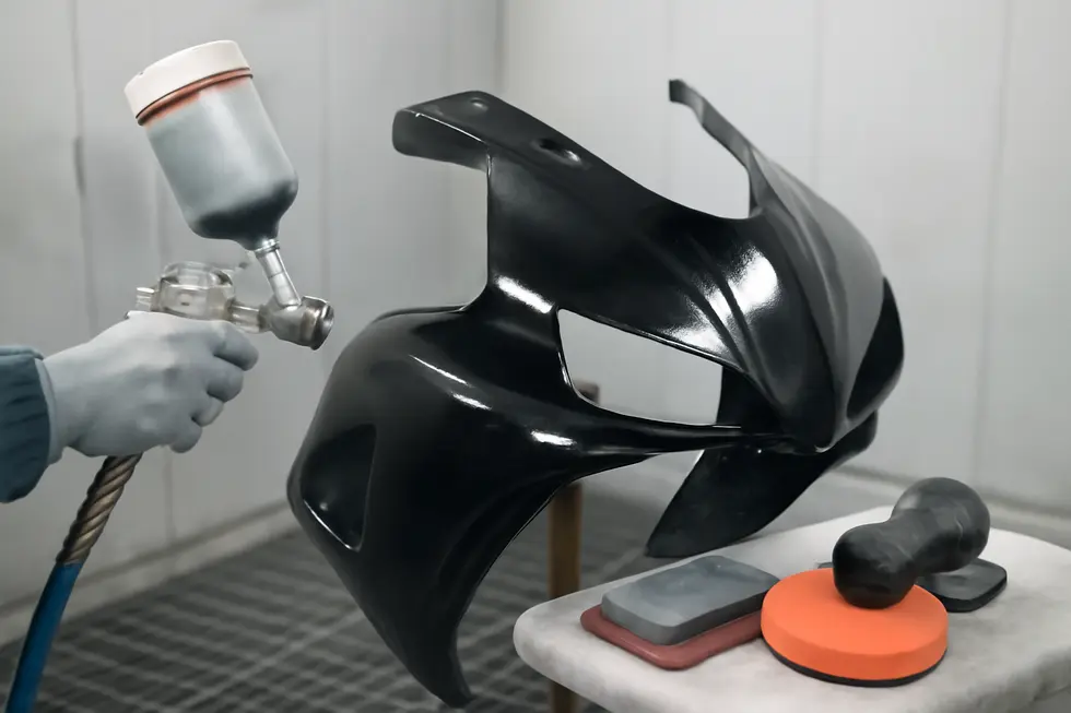 Thorough cleaning and scuffing prepare the motorcycle fairing surface for optimal paint adhesion and finish quality.