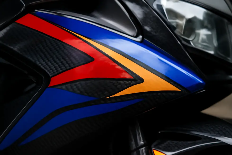 High-quality vinyl decals featuring faux carbon fiber textures on motorcycle fairings highlight material strength and durability.