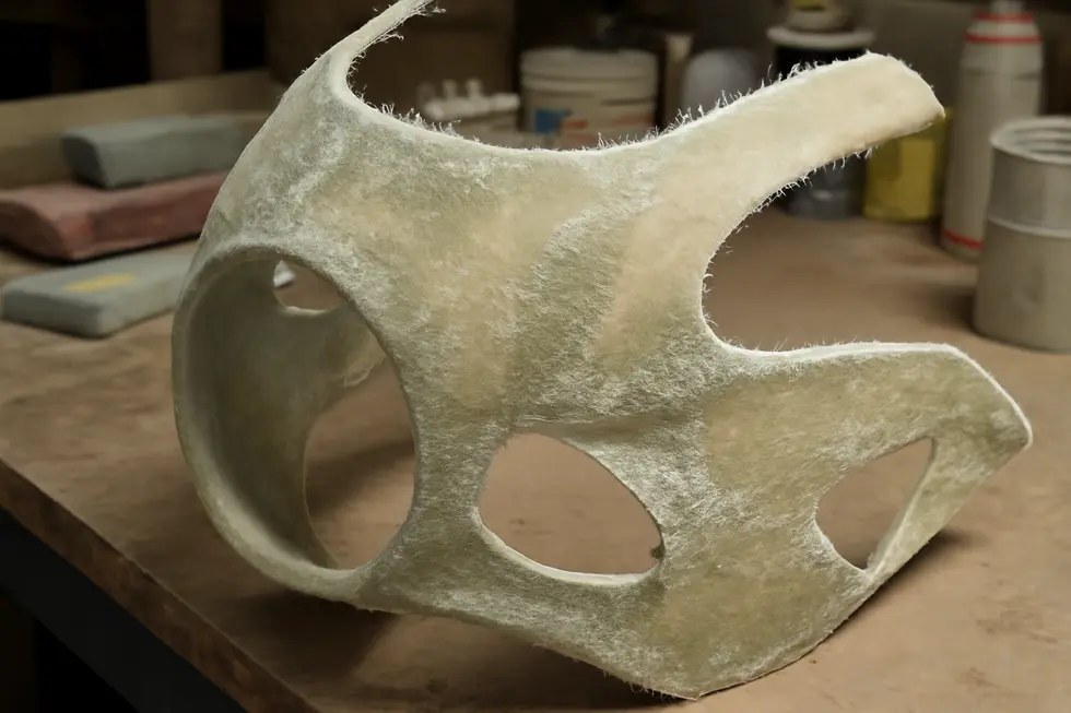 Detailed view of hand-laid fiberglass motorcycle fairings illustrating their raw texture and preparation stages.