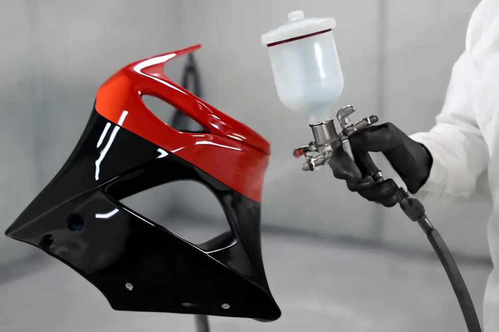 Thorough cleaning and sanding of motorcycle fairings to optimize paint adhesion and durability.